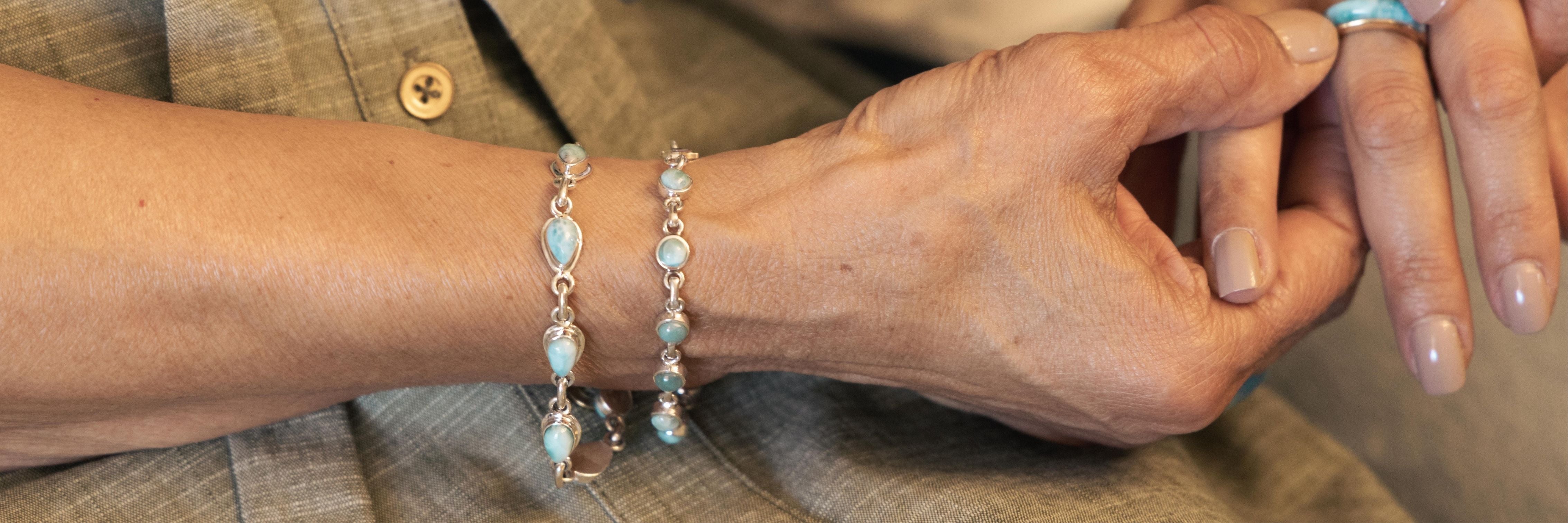 Women wearing two Larimar stone bracelets holding hand with her daughter.