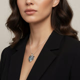 Close-up of a woman wearing a Larimar necklace with a heart-shaped pendant against a neutral background