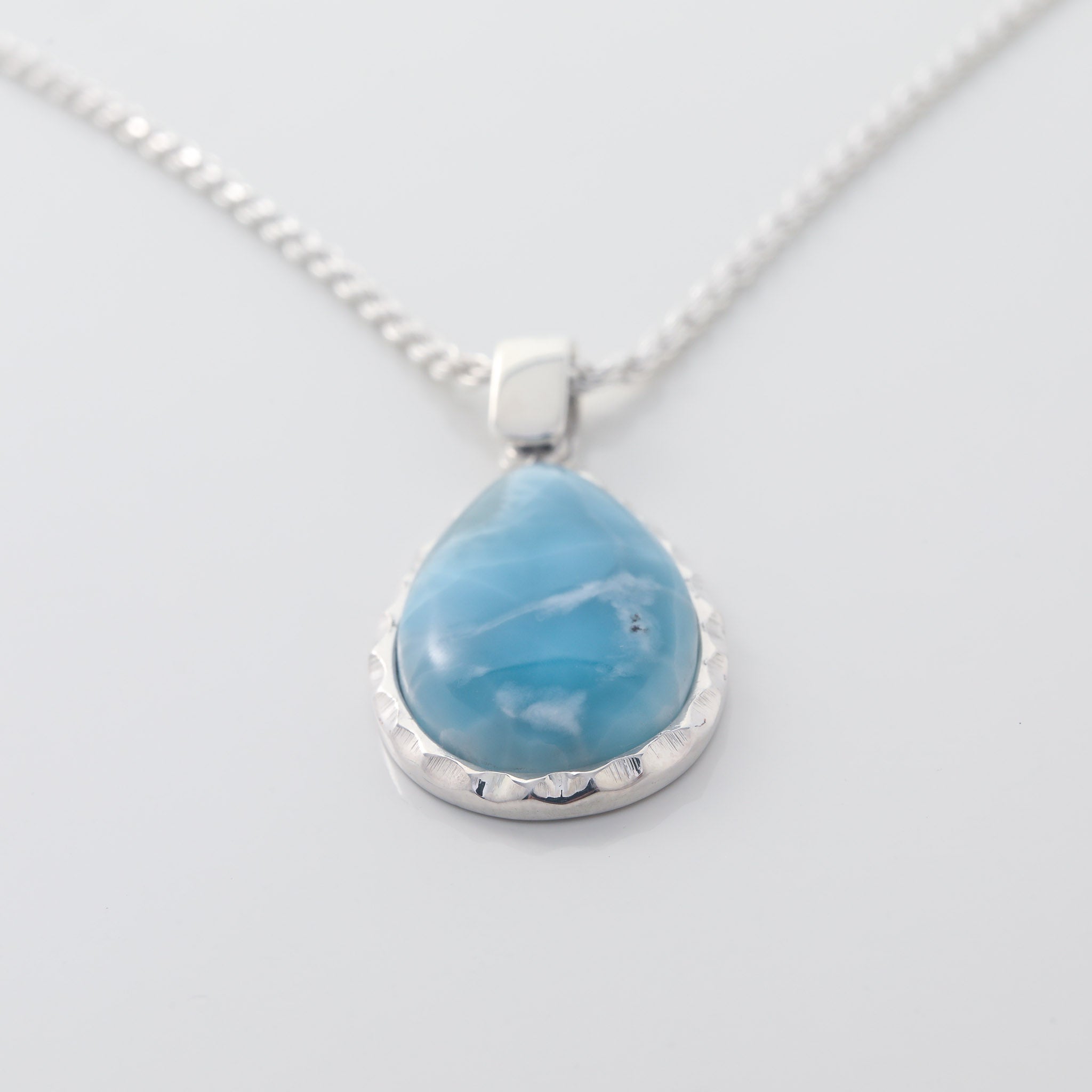 The Larimar Pendant Rhea showcases a Larimar stone with unique geometric edges