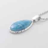 The Larimar Pendant Rhea showcases a Larimar stone with unique geometric edges