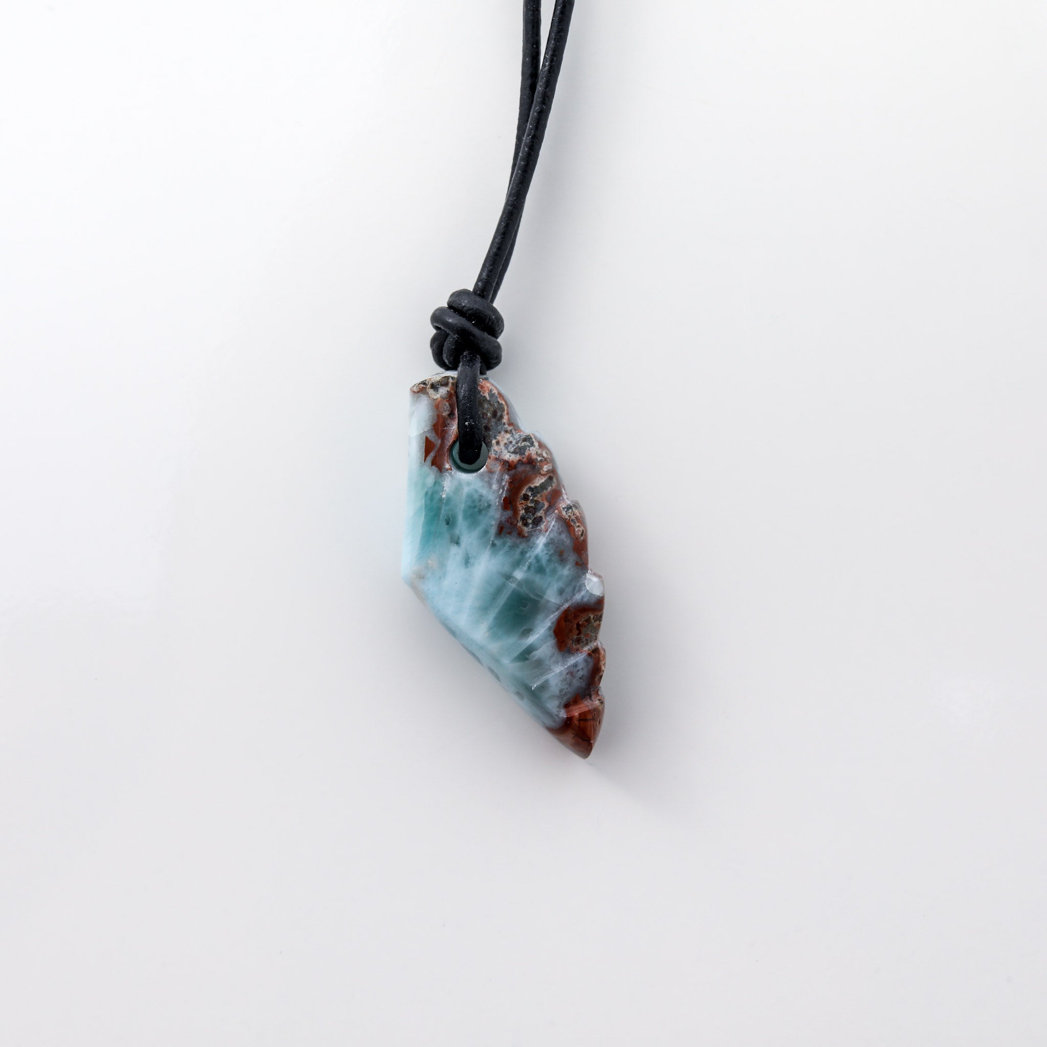 This unique necklace features a wing-shaped larimar stone on a leather cord