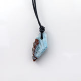 This unique necklace features a wing-shaped larimar stone on a leather cord