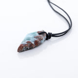 This unique necklace features a wing-shaped larimar stone on a leather cord