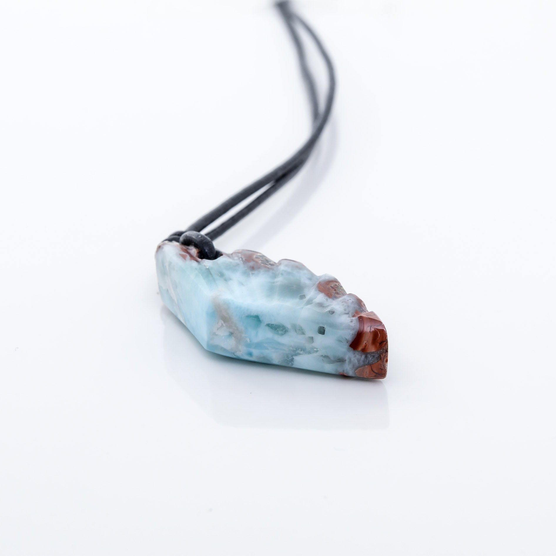 This unique necklace features a wing-shaped larimar stone on a leather cord