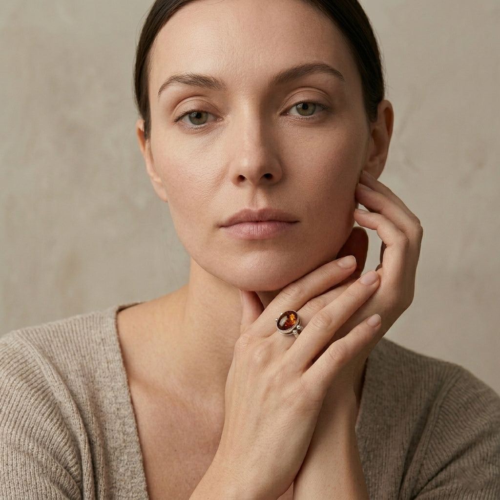 Woman wearing a flip ring with an Amber stone against a neutral background
