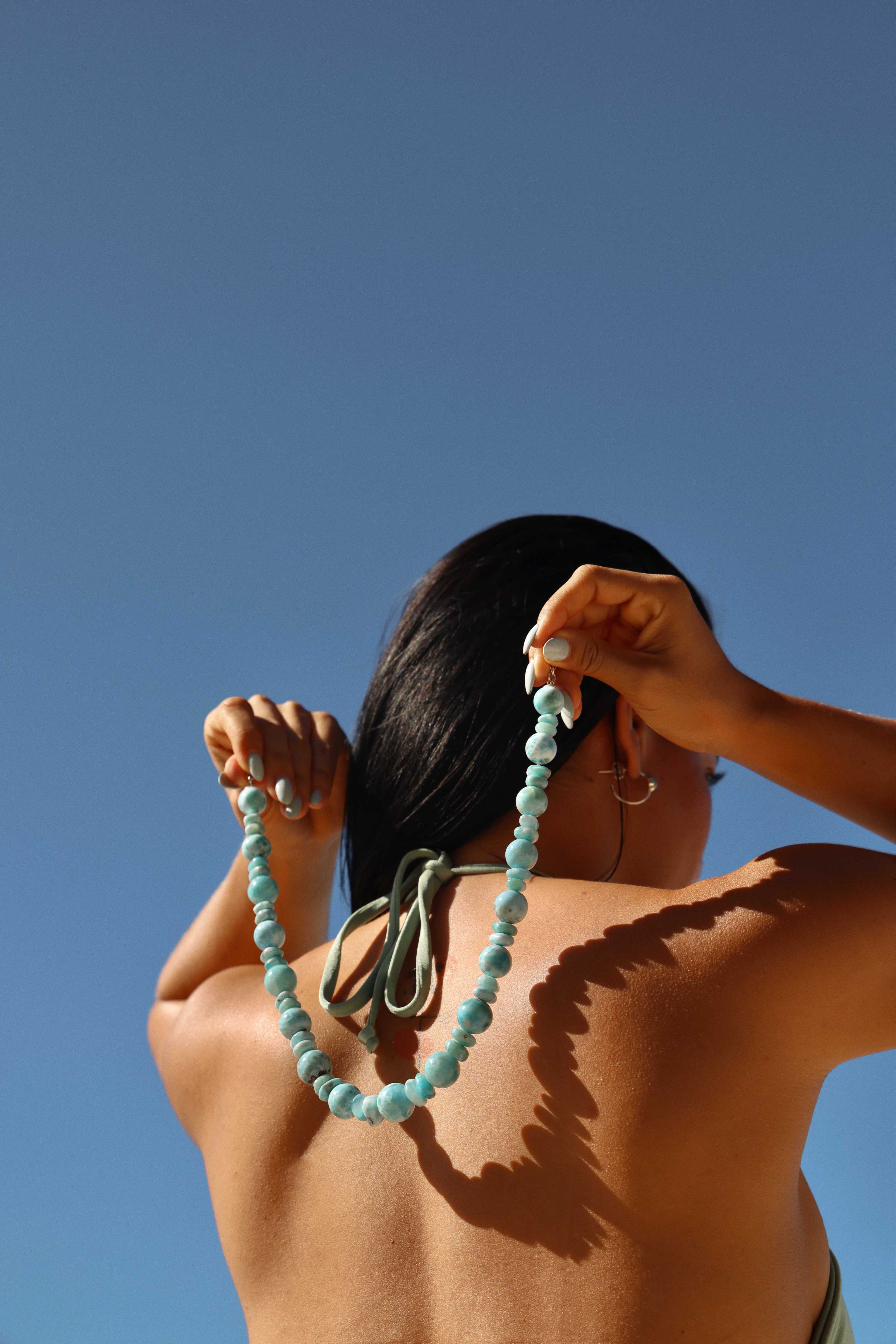 Women showing a Larimar round bead necklace