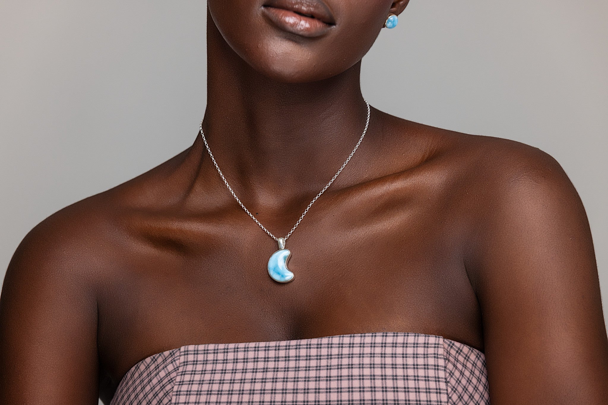 Woman wearing a Larimar pendant necklace against her skin.