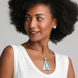 Woman wearing a Larimar necklace on a plain background