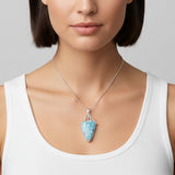 Woman wearing  a Larimar blue pendant against a neutral background