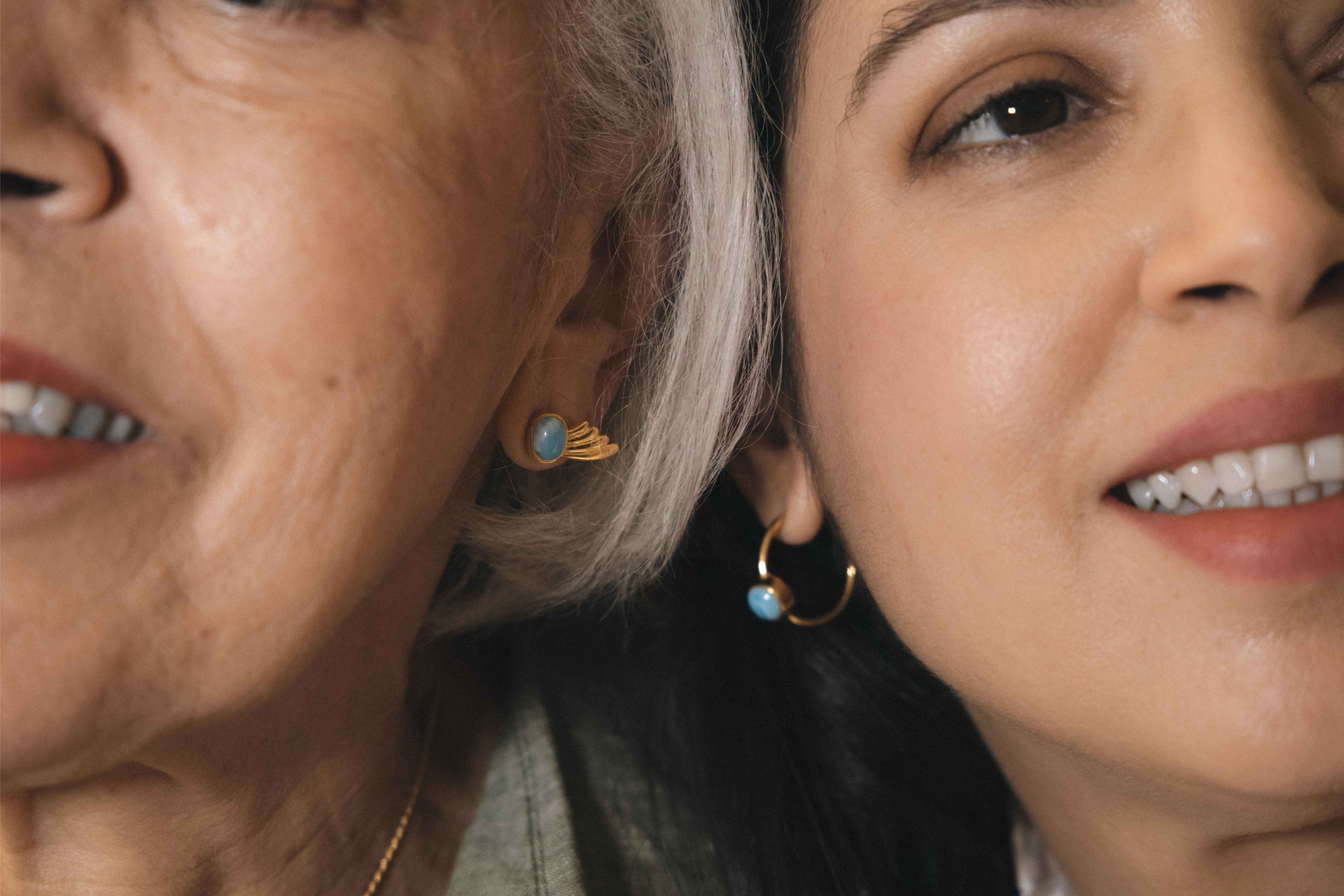 Two women wearing earrings with Dominican Larimar stones.