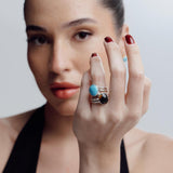 Woman wearing a reversible ring with a blue Larimar gemstone against a neutral background