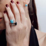 Woman wearing a reversible ring with a blue Larimar gemstone against a neutral background