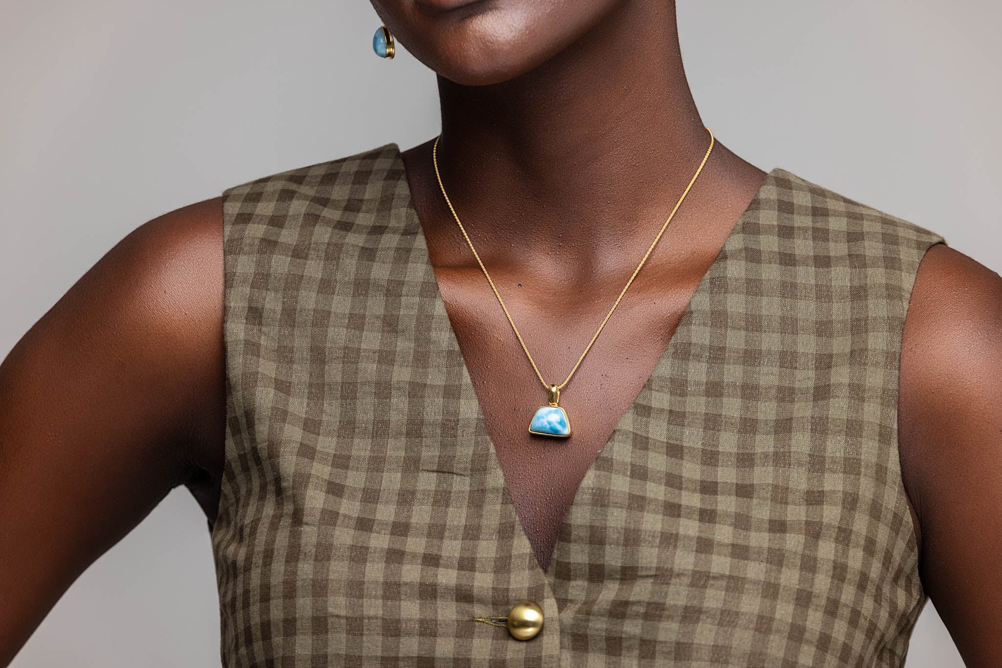 Women wearing the gold Larimar pendant Xianna
